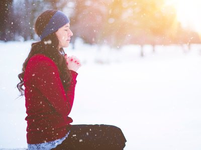 Girl praying in the snow